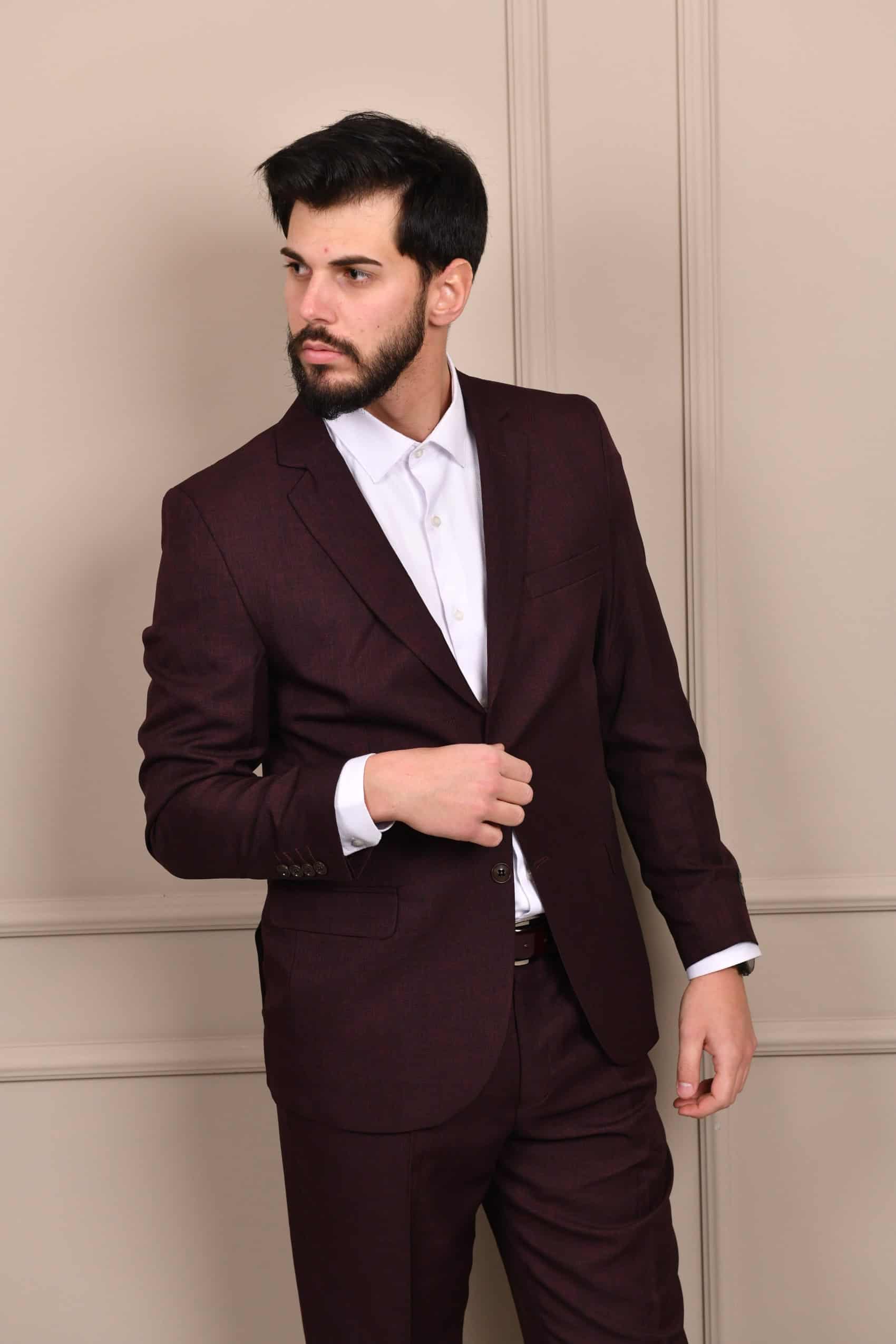 Elegantno muško odelo u tamno bordo nijansi, kombinovano sa belom košuljom i prslukom, idealno za svečane prilike i poslovne događaje.