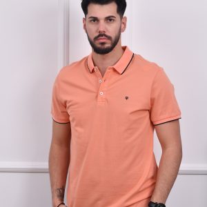 Muškarac nosi narandžastu polo majicu sa kratkim rukavima i kontrastnim detaljima na ovratniku, jednostavan i elegantan dizajn za sve prilike.
