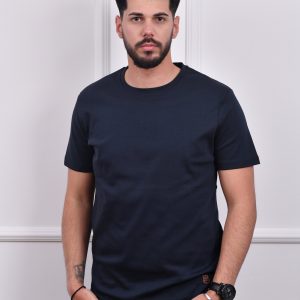 Muškarac nosi tamno plavu majicu sa kratkim rukavima i malim logotipom, savršenu za casual stil i svakodnevne prilike.