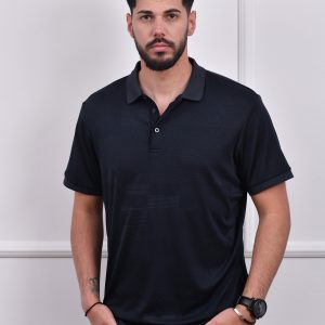 Muškarac nosi tamno plavu polo majicu sa kratkim rukavima, elegantan dizajn sa suptilnim šarama, idealna za casual i poslovne prilike.