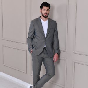 Muško sivo odelo sa slim fit krojem, moderno i elegantno, u kombinaciji sa belom majicom i sportskim tenisicama za sofisticiran, ali opušten izgled.